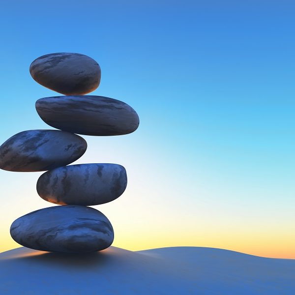 3D render of balancing pebbles on sand against a sunset sky